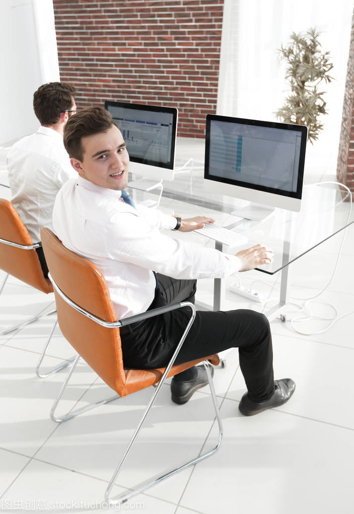 坐在桌子后面的辦公室生活 員工與辦公設(shè)備